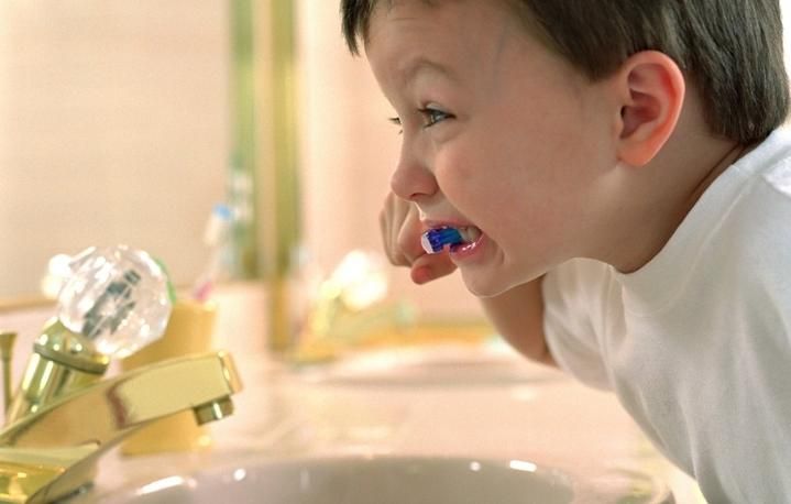 a criança escova os dentes