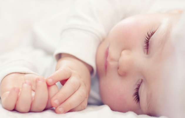 Nærbilde portrett av en vakker sovende baby på hvitt
