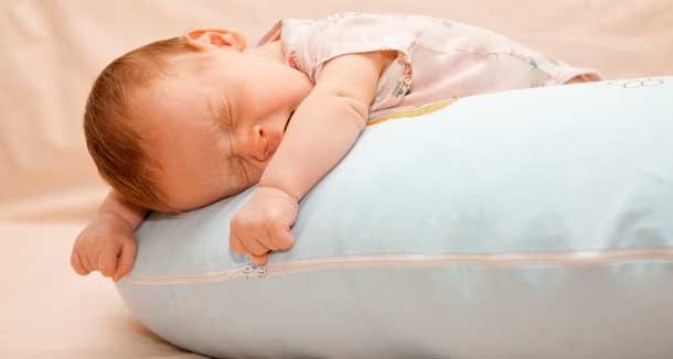 bebé recién nacido durmiendo sobre una almohada