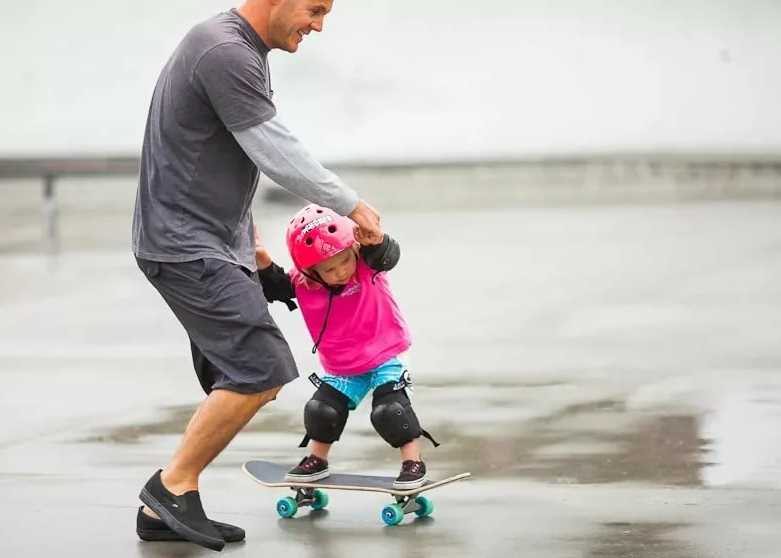 far og baby på skateboard